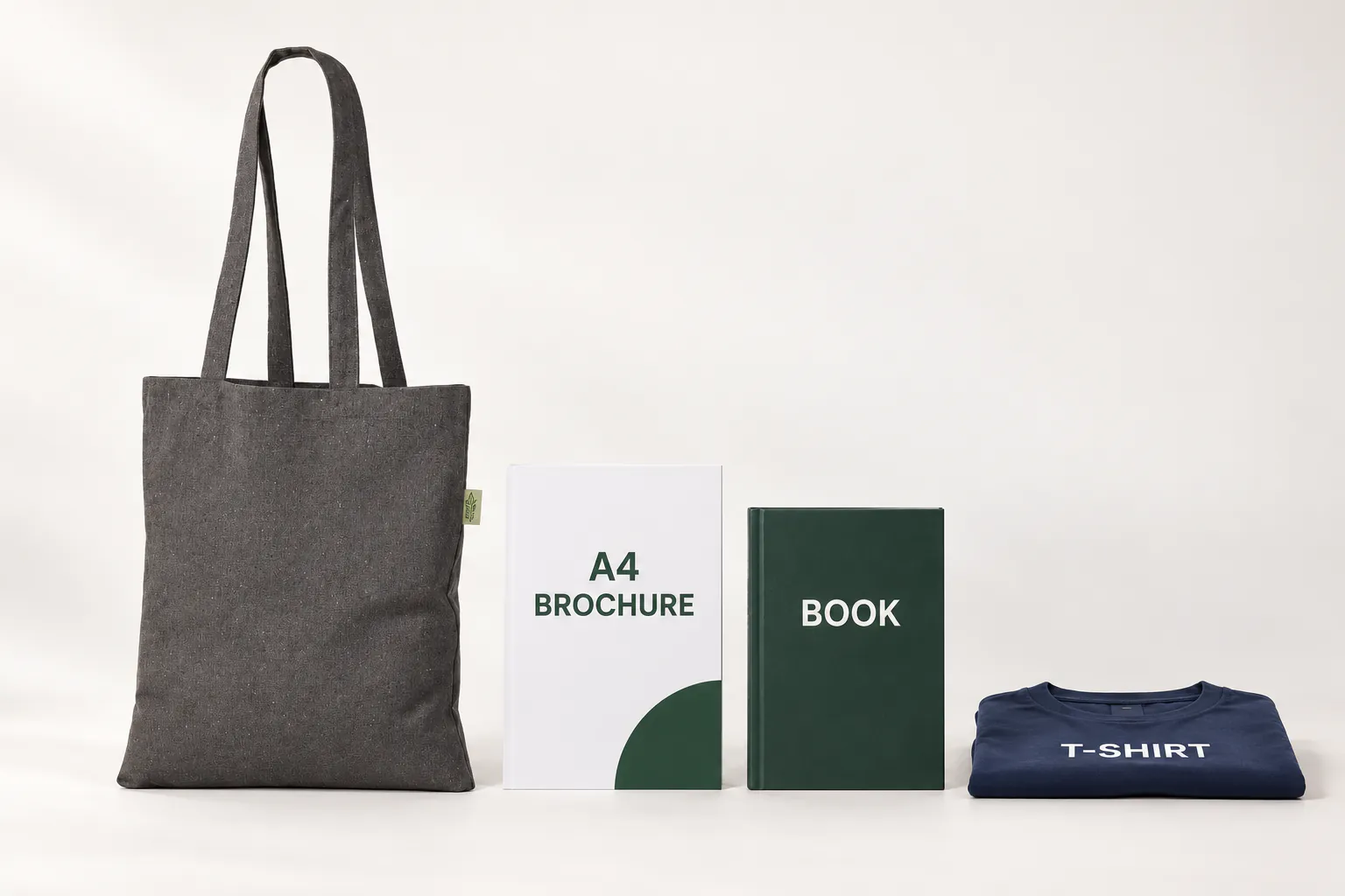 Mörkgrå återvunnen tygkasse bredvid en A4-broschyr, en bok och en platt vikt t-shirt.