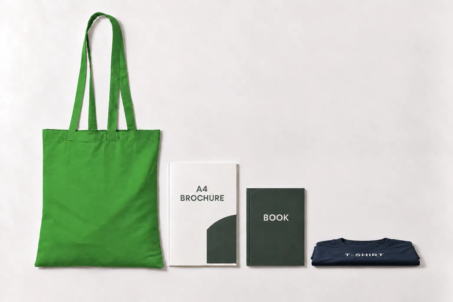 Ljusgrön bomullskasse bredvid en A4-broschyr, en bok och en hopvikt t-shirt som ligger platt.