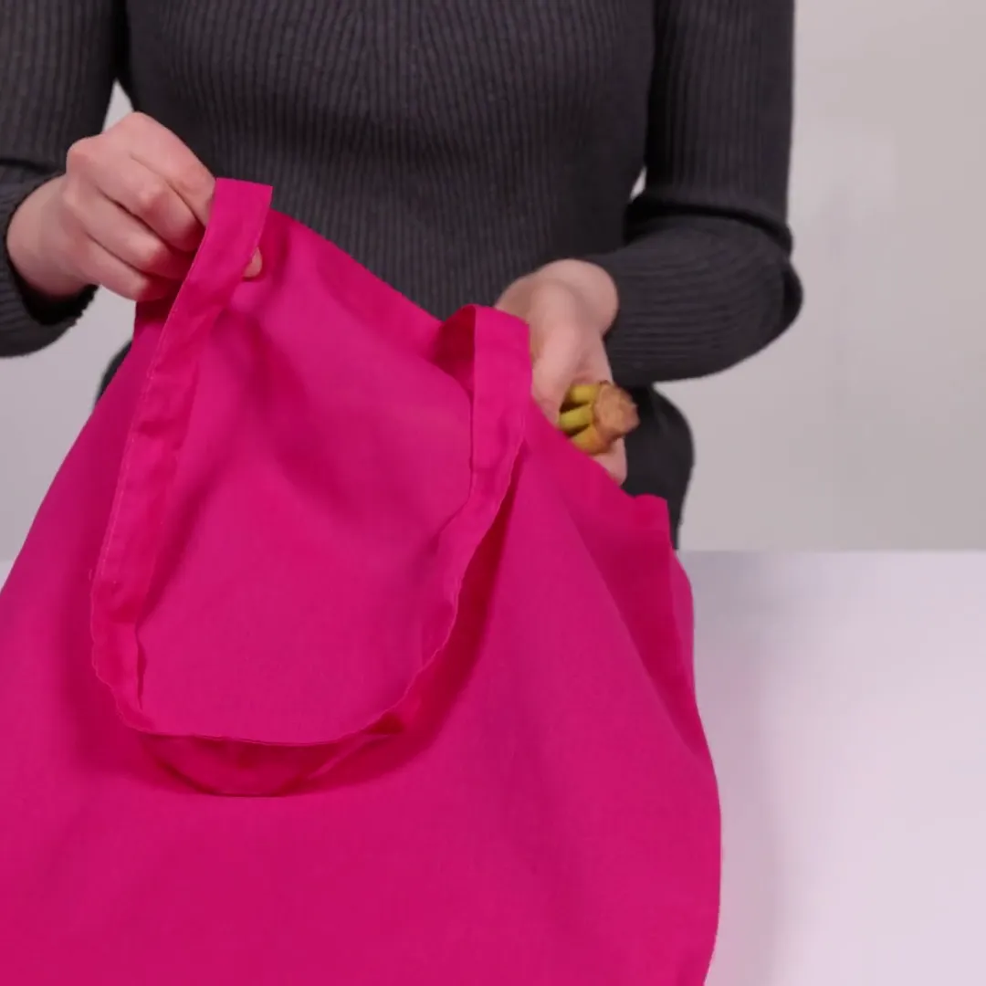 Bomullskasse, 140 g/m², visad av en person i produktvideon – magenta