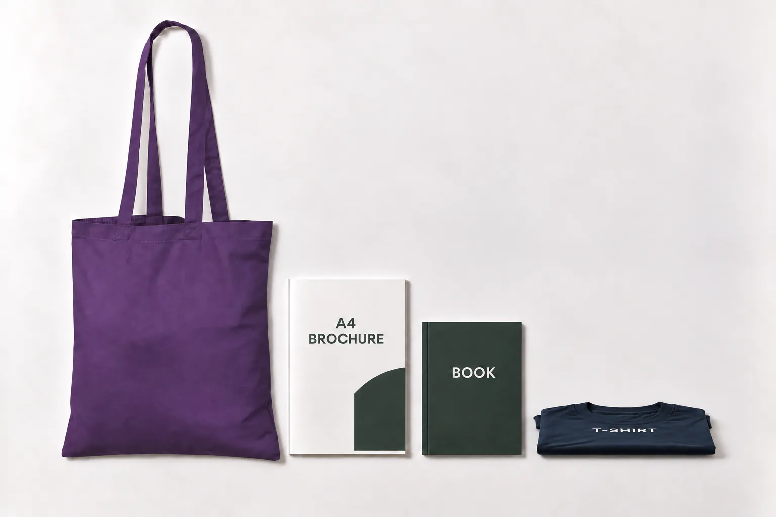 Violett bomullskasse bredvid en A4-broschyr, en bok och en hopvikt t-shirt som ligger platt.